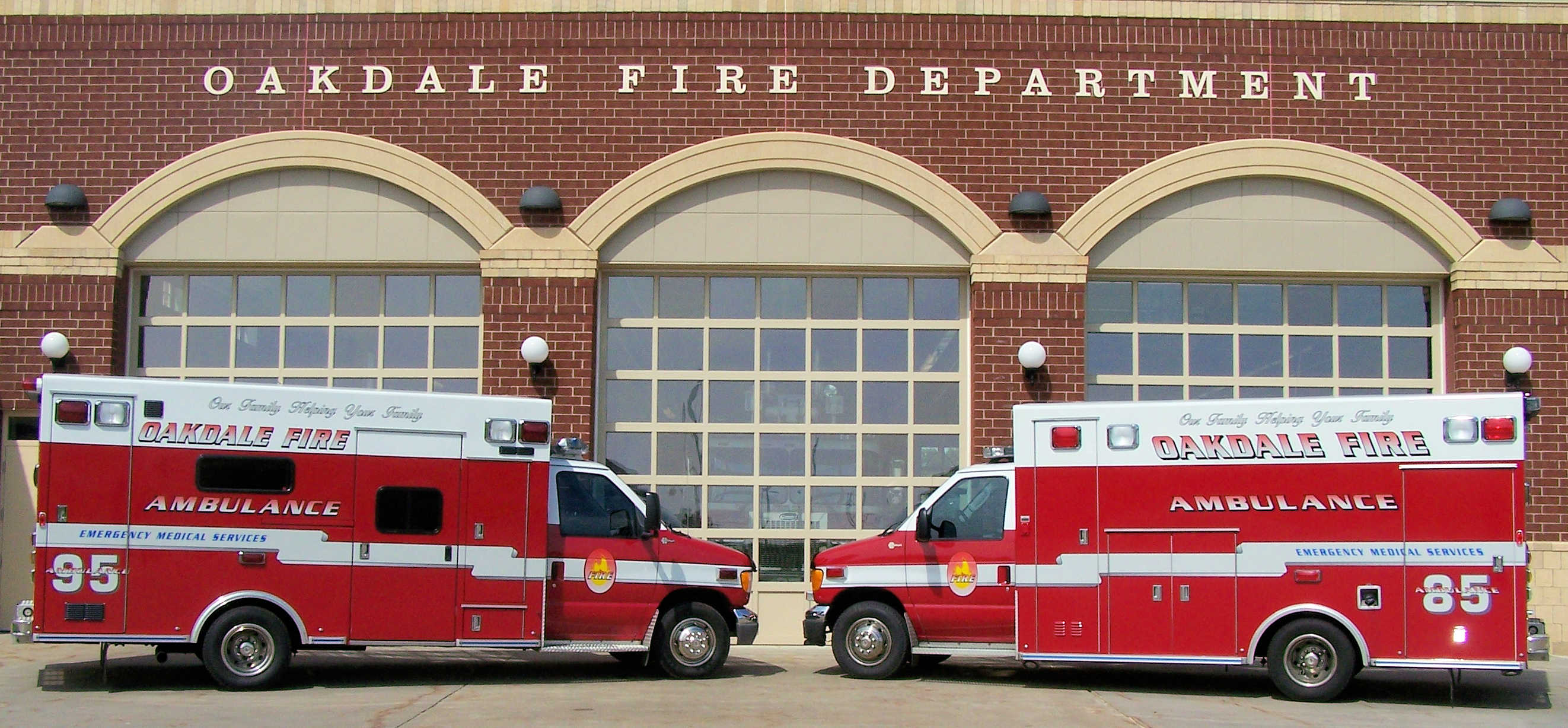 Two Oakdale fire department ambulances parked in front of a fire station